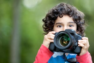 Kid playing around with a camera at the park