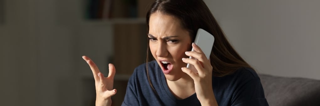 Woman yelling angrily into cell phone