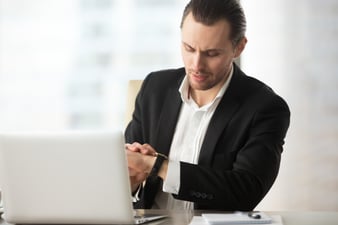 businessman-looking-wristwatch-work-desk-office