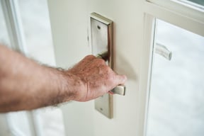 cropped-anonymous-man-holding-door-handle-open-door