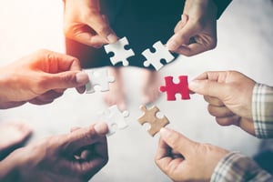 hands-holding-piece-of-blank-jigsaw-puzzle-for-teamwork-workplace-success-and-strategy-concept
