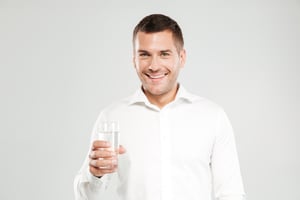 happy-young-man-holding-glass-full-water