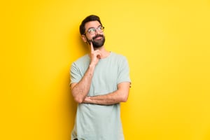 man-with-beard-green-shirt-thinking-idea-while-looking-up