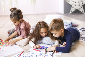 three-focused-children-are-playing-floor-drawing-coloring-books