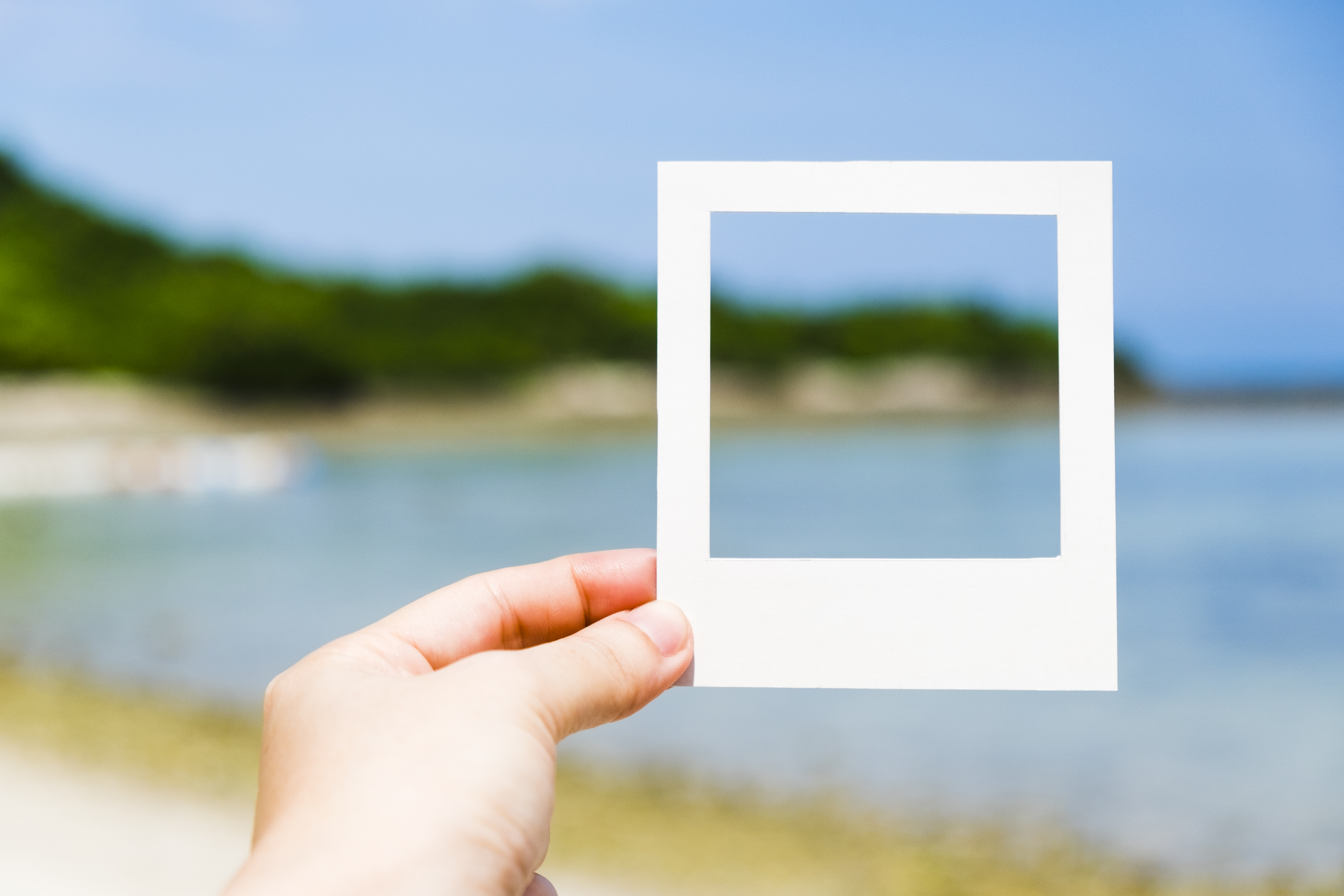 polaroid picture frame help in front of a lake 