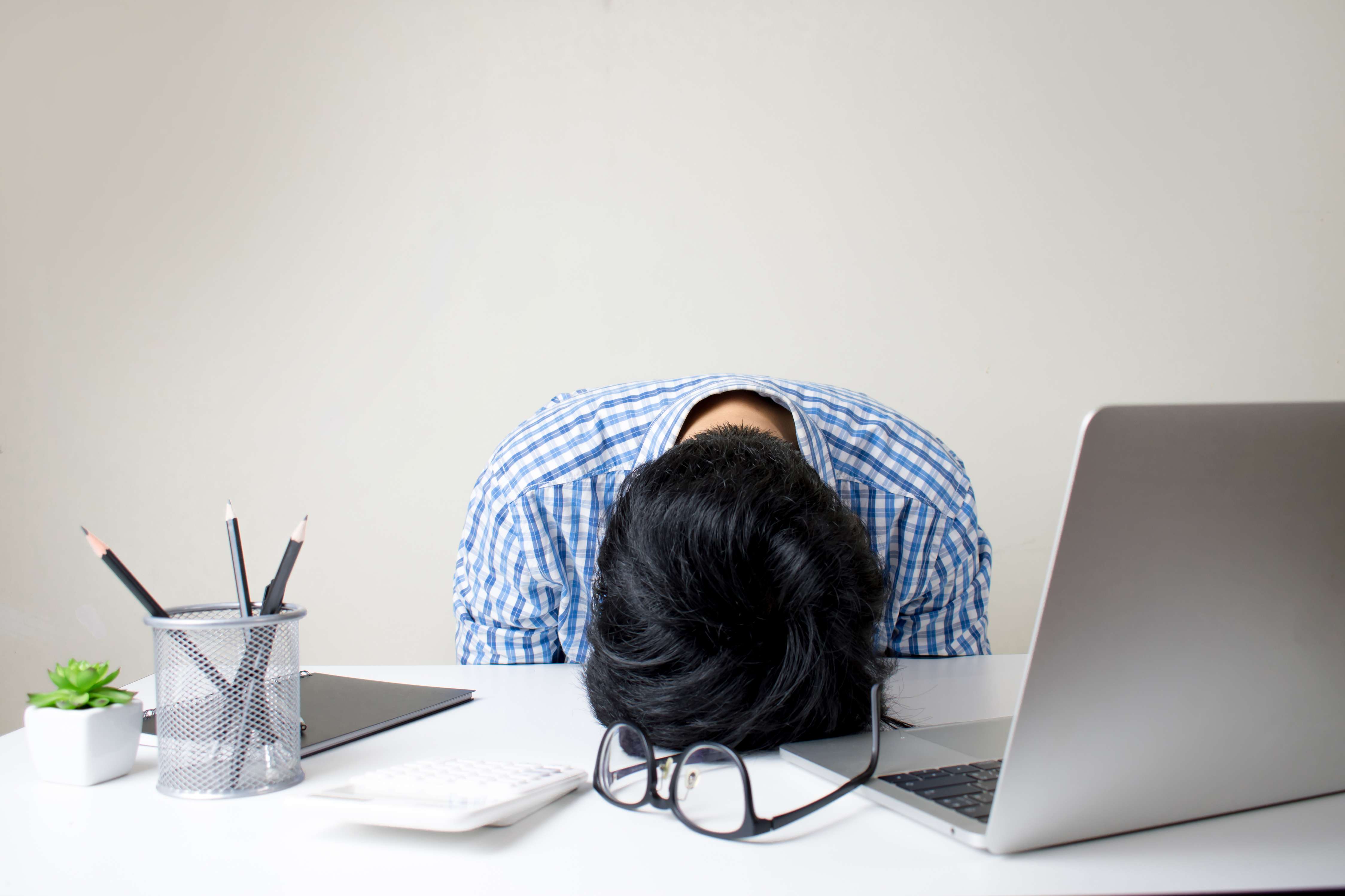 man with head rested on desk 