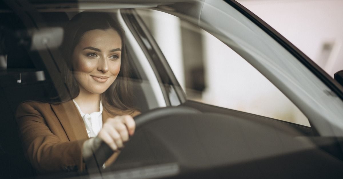 woman driving with a big smile on her face