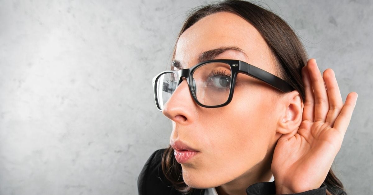 Woman holding her ear out to listen