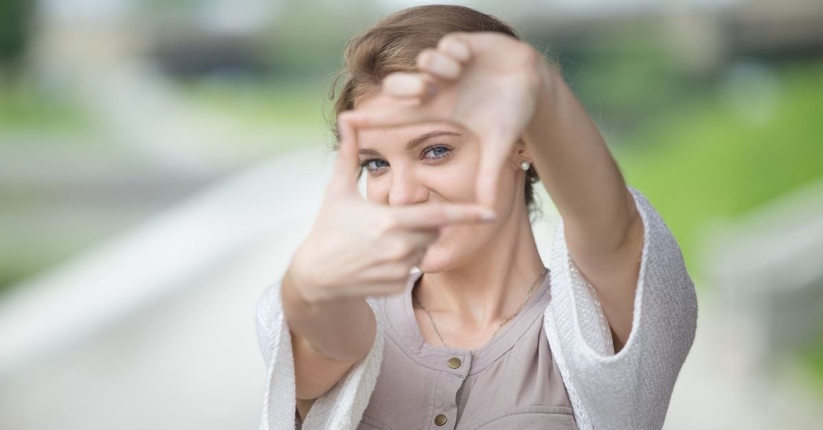 Woman holding out her hands to make a square that she is looking through 