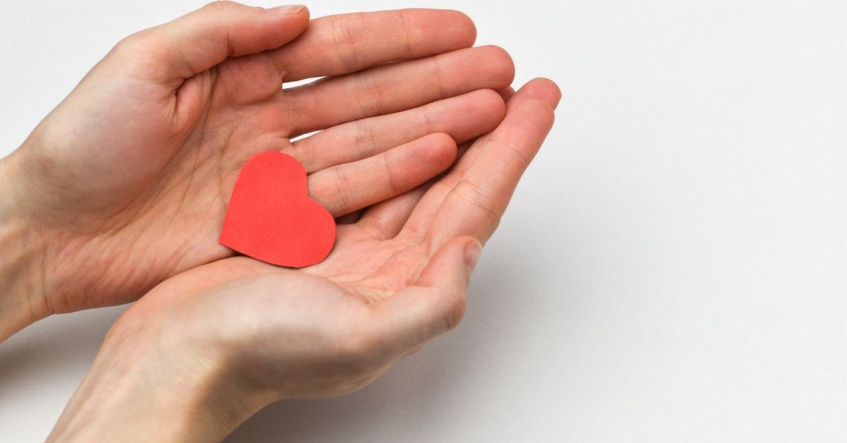 hands holding red paper heart