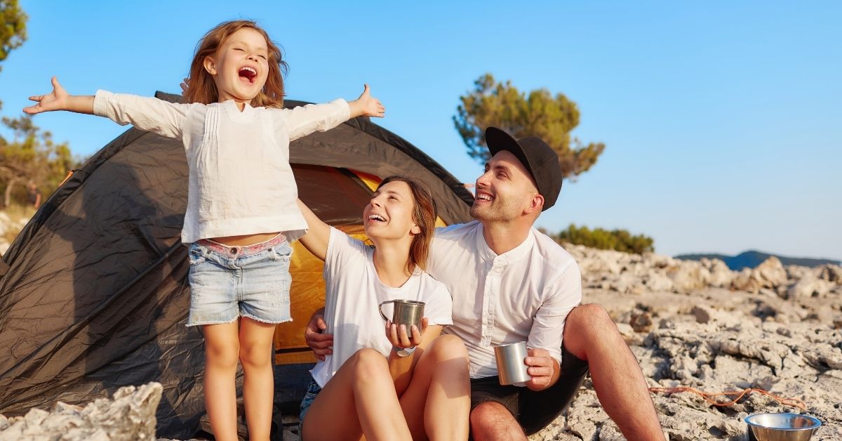 family outside tent resting