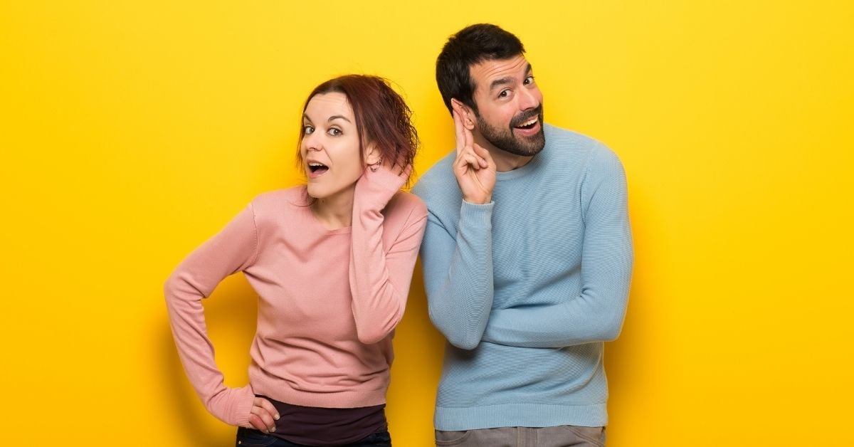 man and woman holding hands to their ears to listen