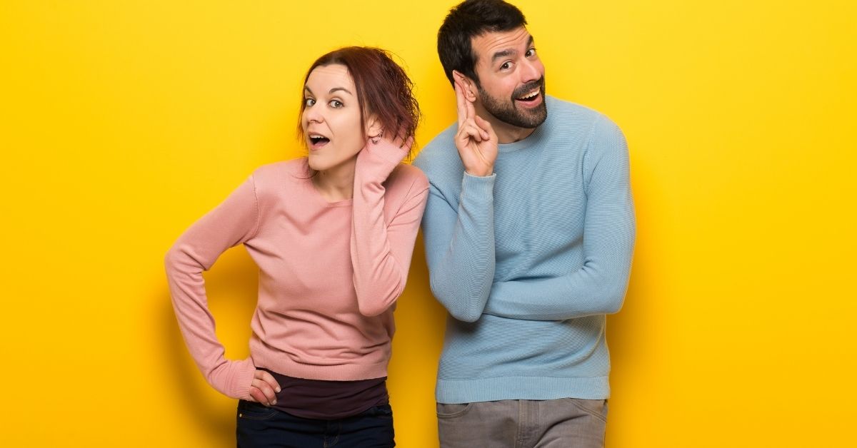 man and woman holding their ears as if they're excitedly listening to you