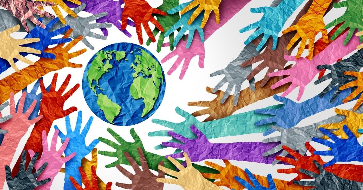 colorful hand and arms all reaching for an earth - all made out of paper