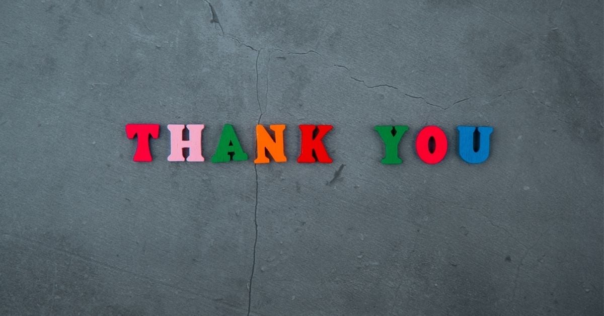 colorful word magnets that spell out the words "thank you" on a black background