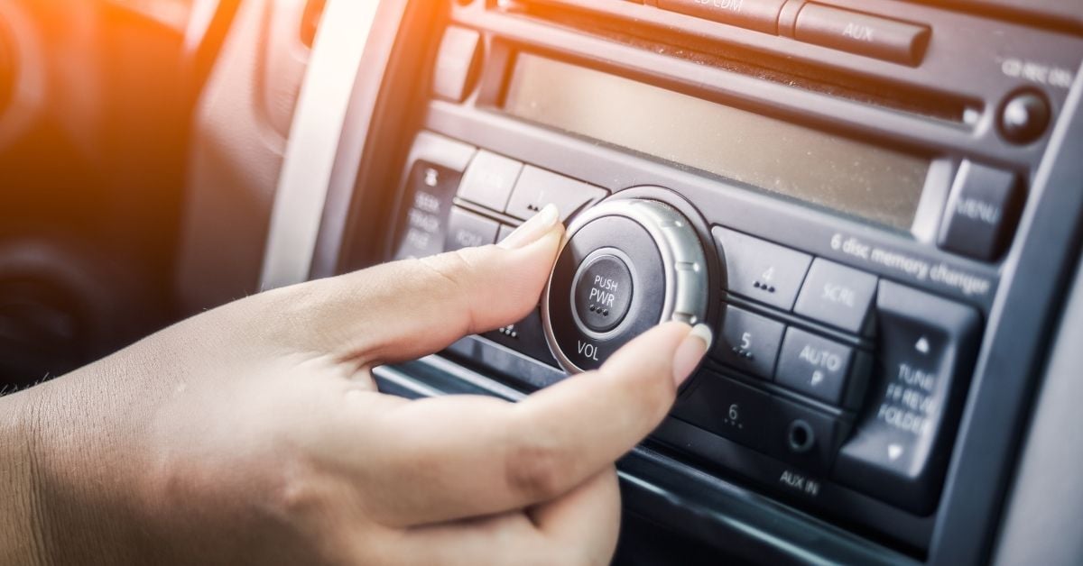 hand turning down the radio dial in a car