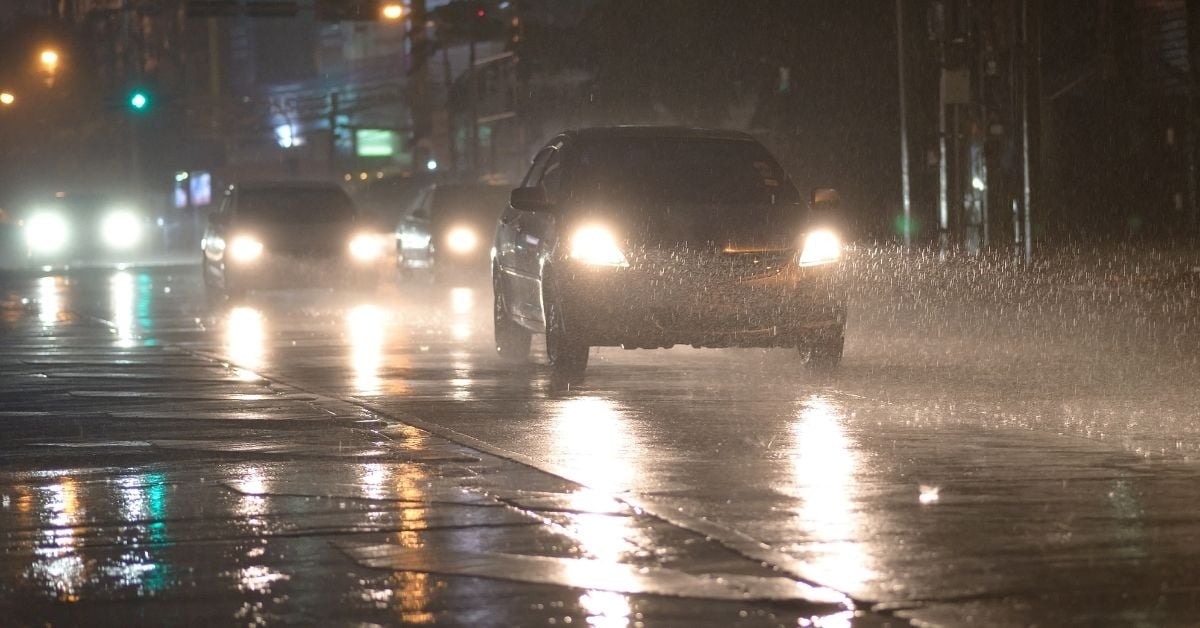 car driving with headlights on in the rain