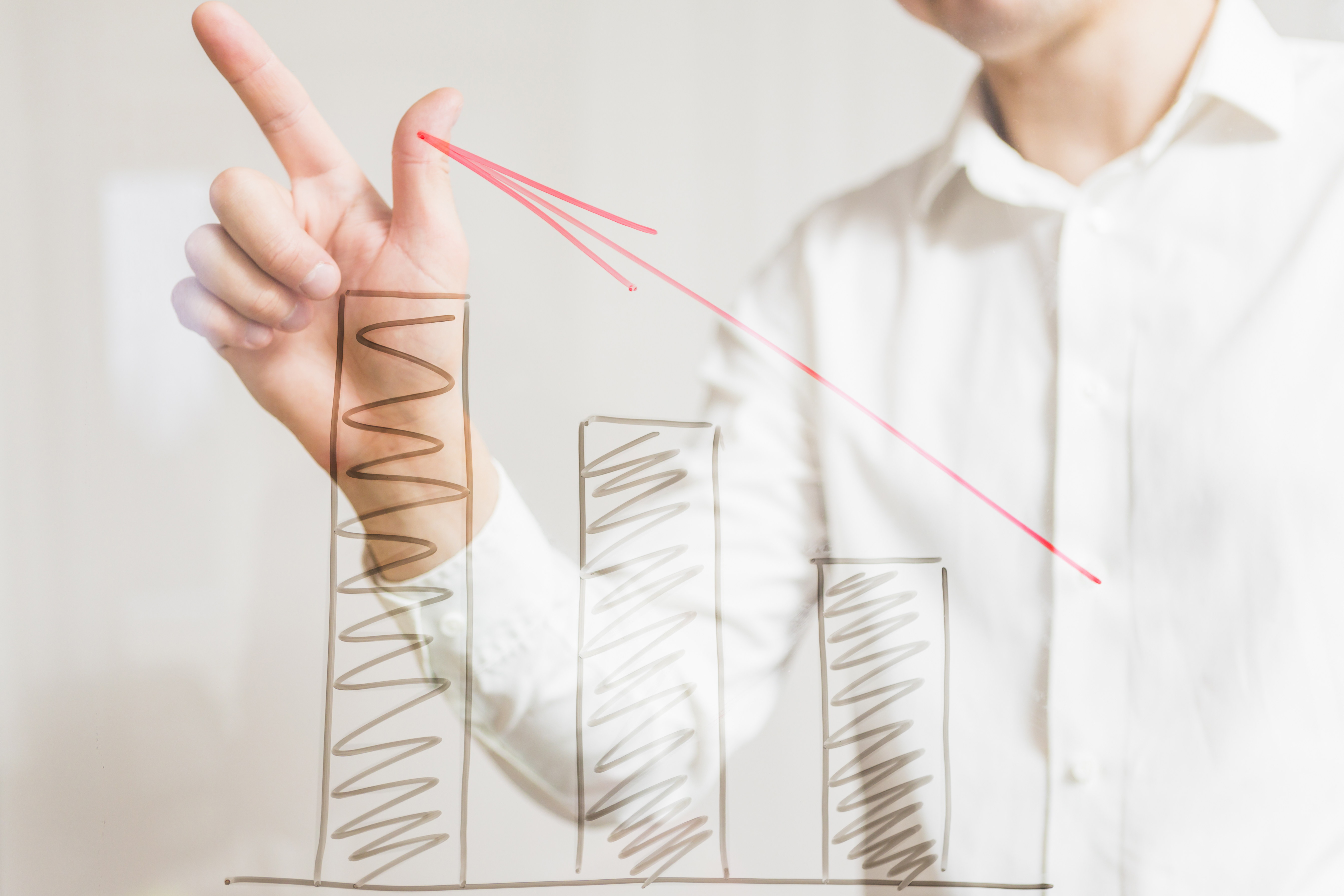 businessperson-gesturing-increasing-graphs-with-red-arrow-glass-board