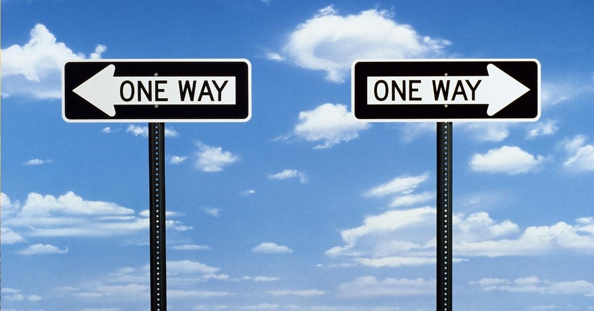 two one way signs pointing in opposite directions